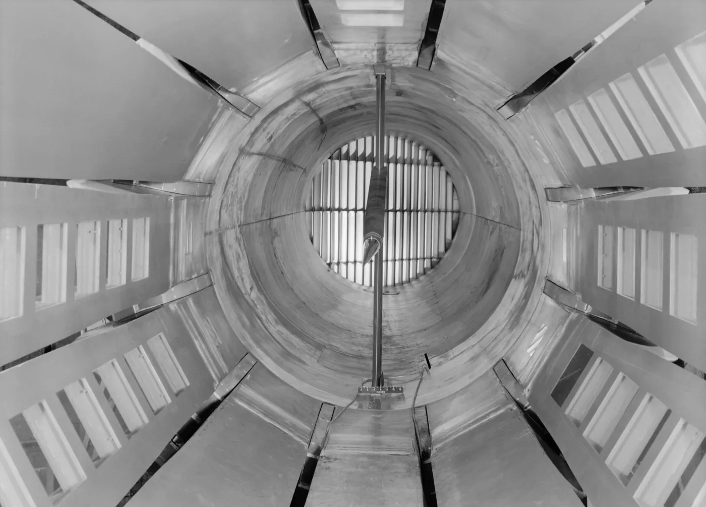 Looking upstream through a twelve-sided wind-tunnel test section with long slots between the wall panels and a model on a sting at the centre